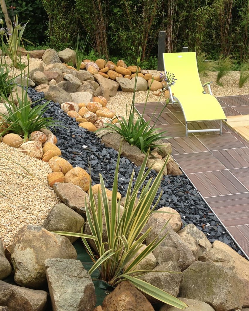 Paysage jardin avec chaise longue près de piscine.