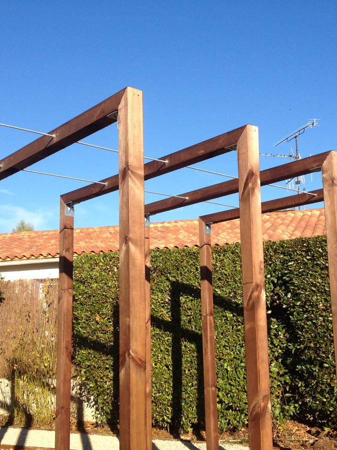 Structure en bois dans un jardin ensoleillé.